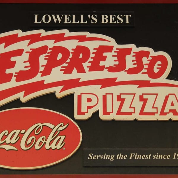 Espresso Pizza sign with red and white lettering, a Coca-Cola logo, and "Lowell's Best" text.