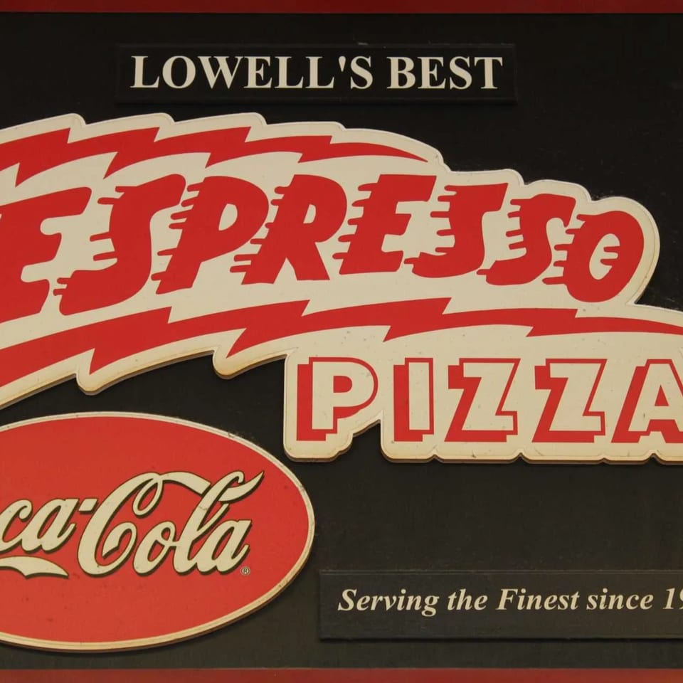 Espresso Pizza sign with red and white lettering, a Coca-Cola logo, and "Lowell's Best" text.