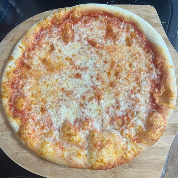 Espresso Pizza's classic cheese pizza with a golden crust on a wooden serving board.