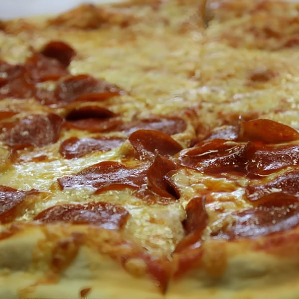 Close-up of a freshly baked Espresso Pizza pepperoni pizza, with melted cheese and glistening pepperoni slices.