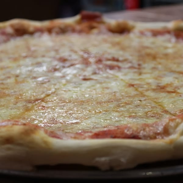 Close-up of a freshly baked Espresso Pizza cheese pizza, glistening with melted mozzarella and sauce.